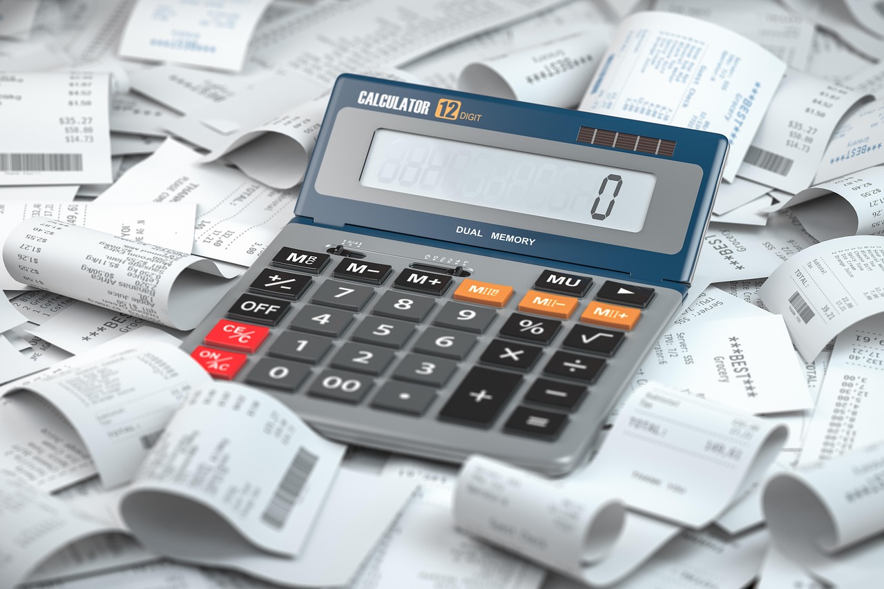 A calculator surrounded by receipts