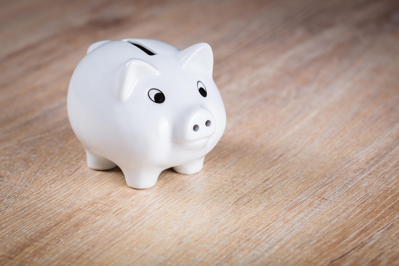 A white piggy bank on a wooden table