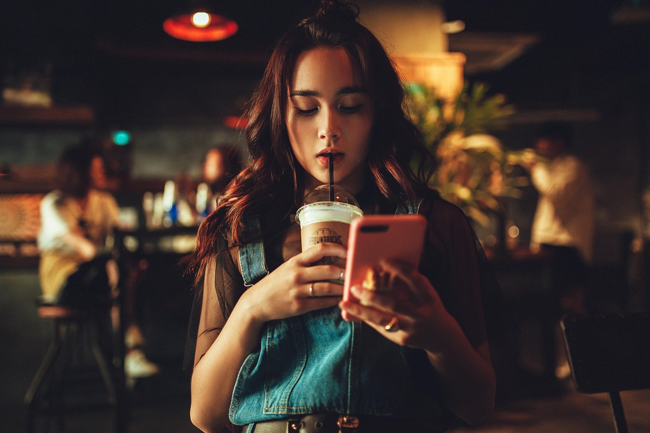 A woman reading on her smartphone in a cafe