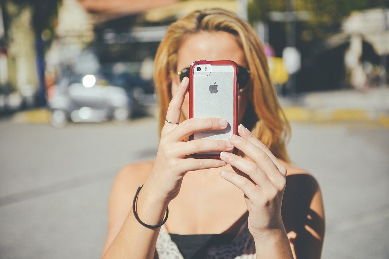 A woman taking a photo with her smartphone