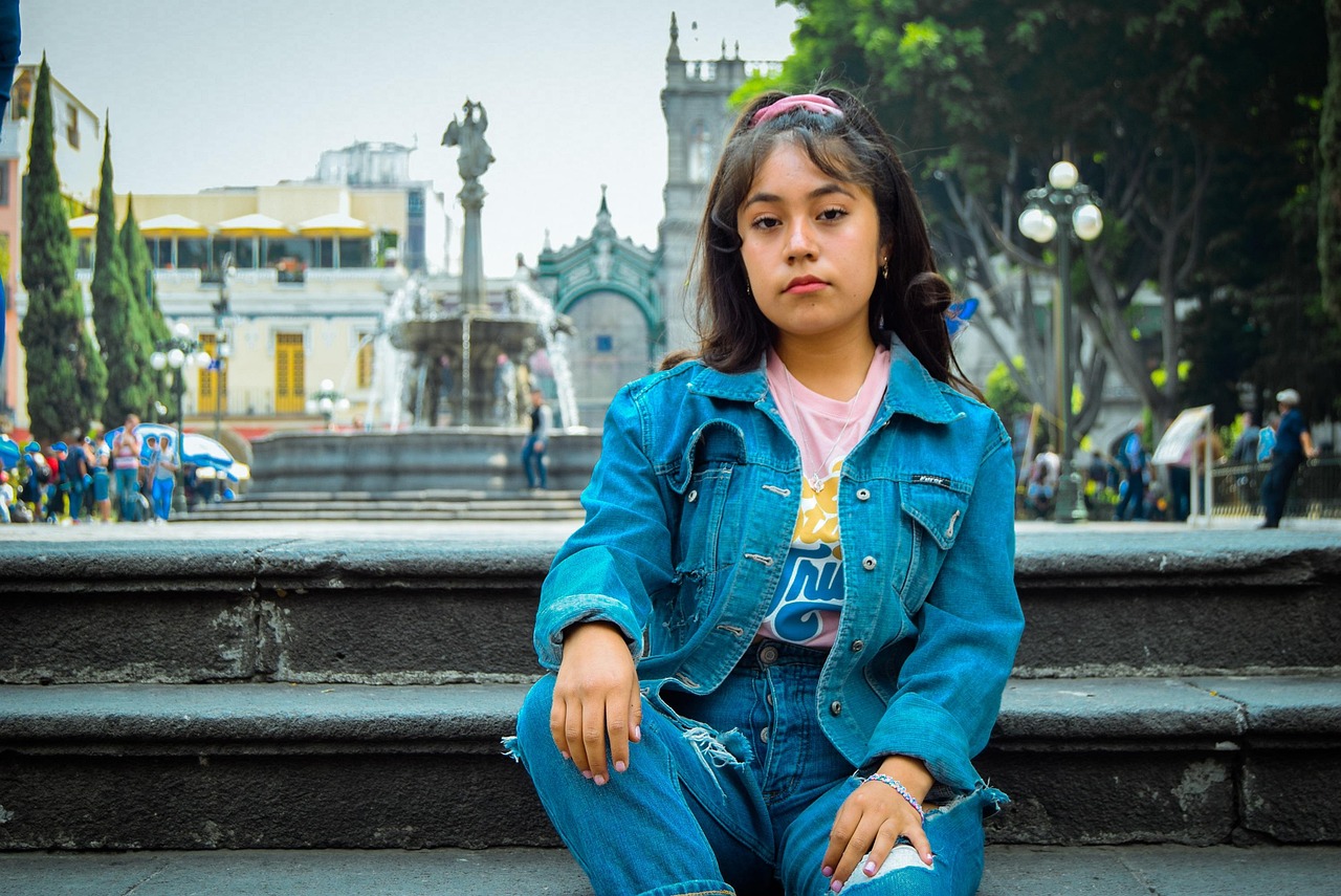 A young woman in denim posing on the street