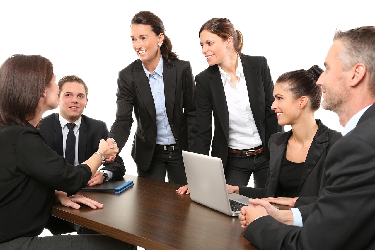 Business partners shaking hands across a meeting table