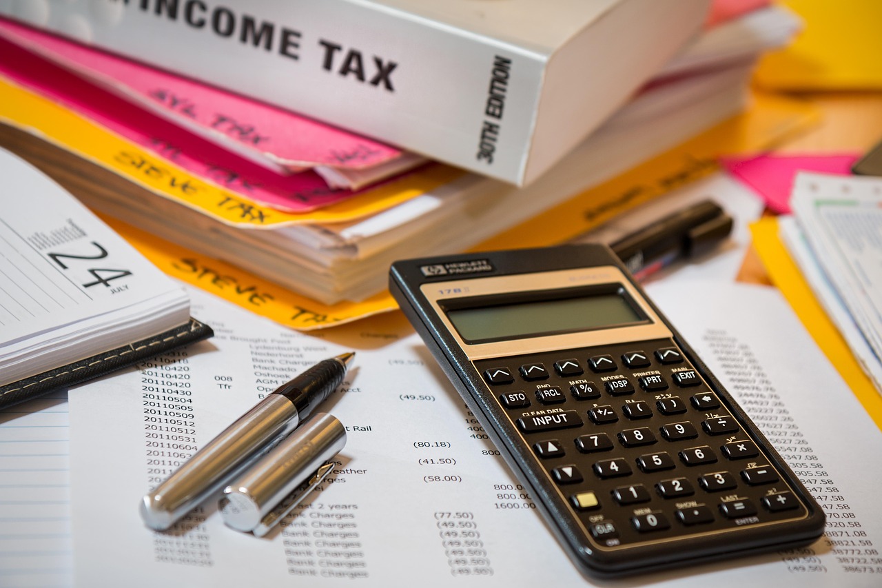 A calculator and pens on budget paperwork