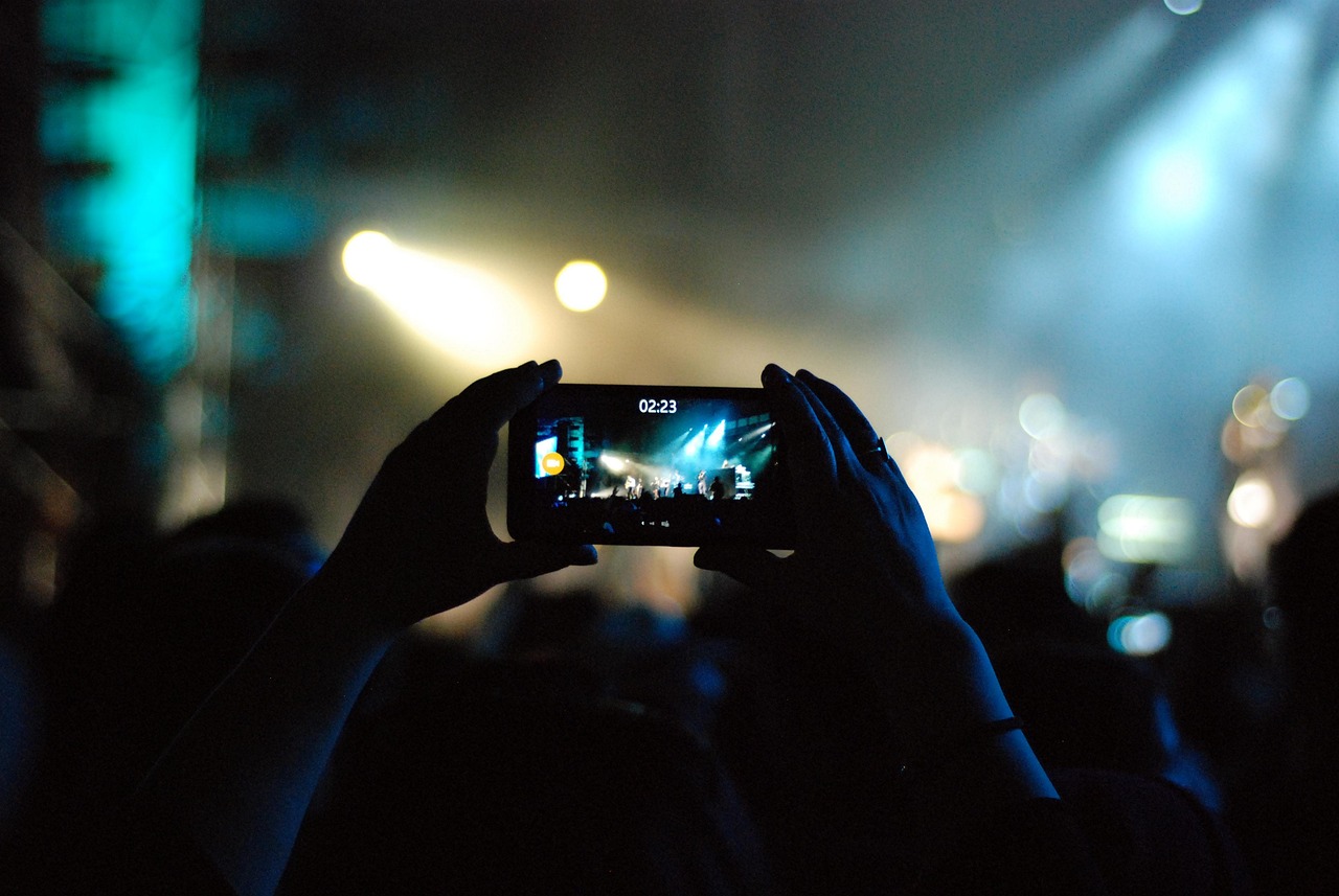 A fan recording a live show on a smartphone